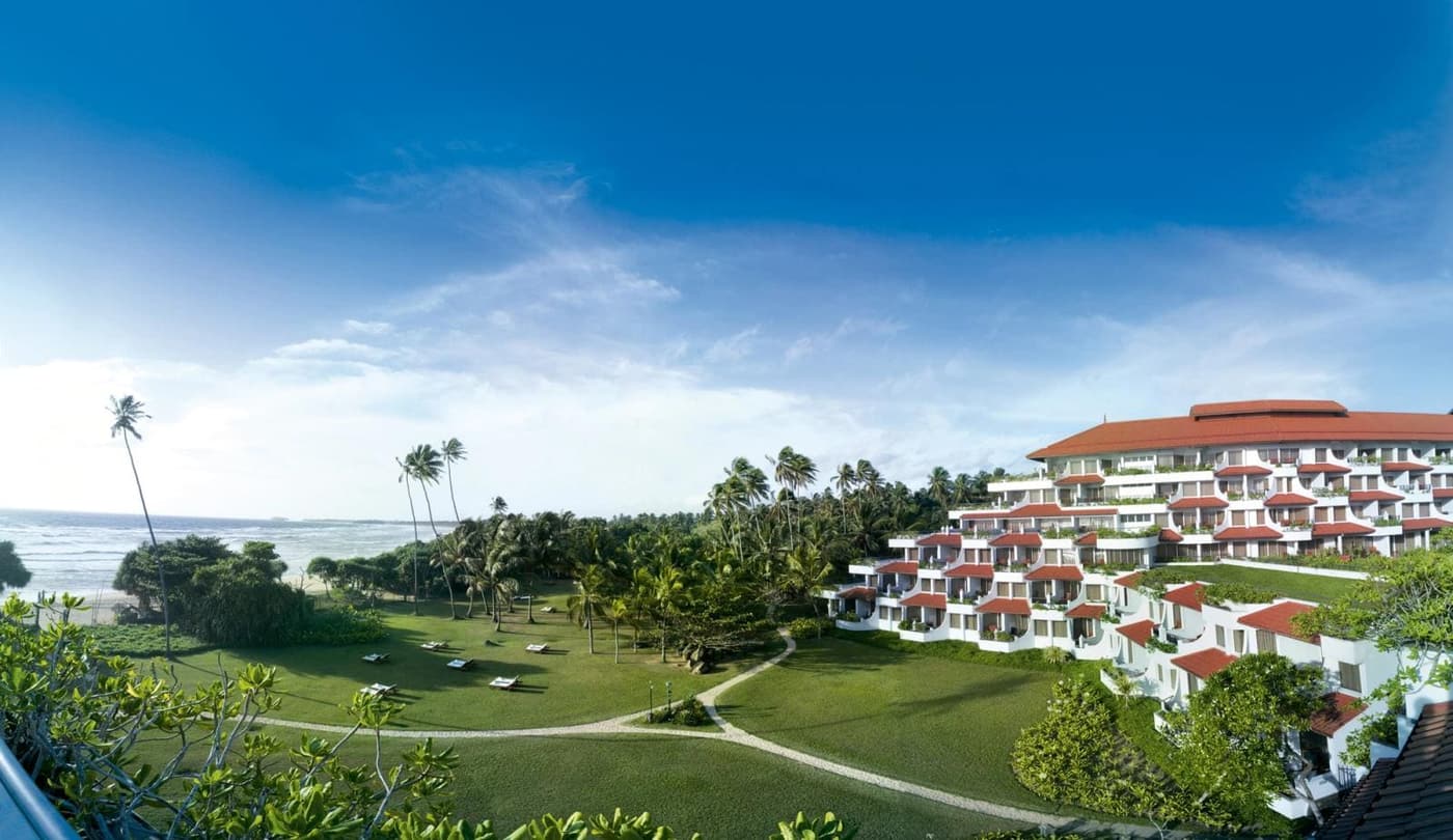 A white resort above the beach and the lawns at Bentota